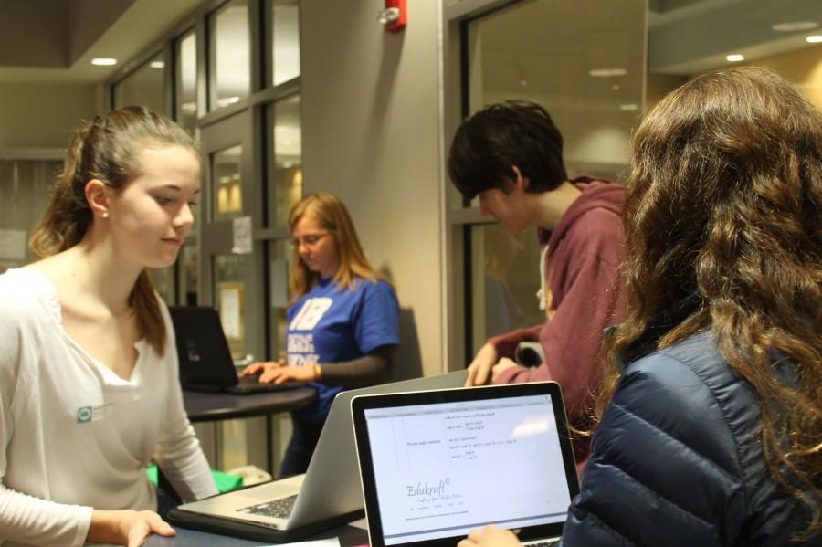 Junior Claire Pfeifer works with her group to help solve the school wifi issues.