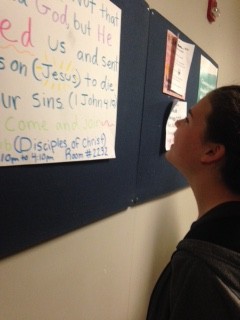 Freshman Lea Edgar looks at a Disciples of Christ club poster