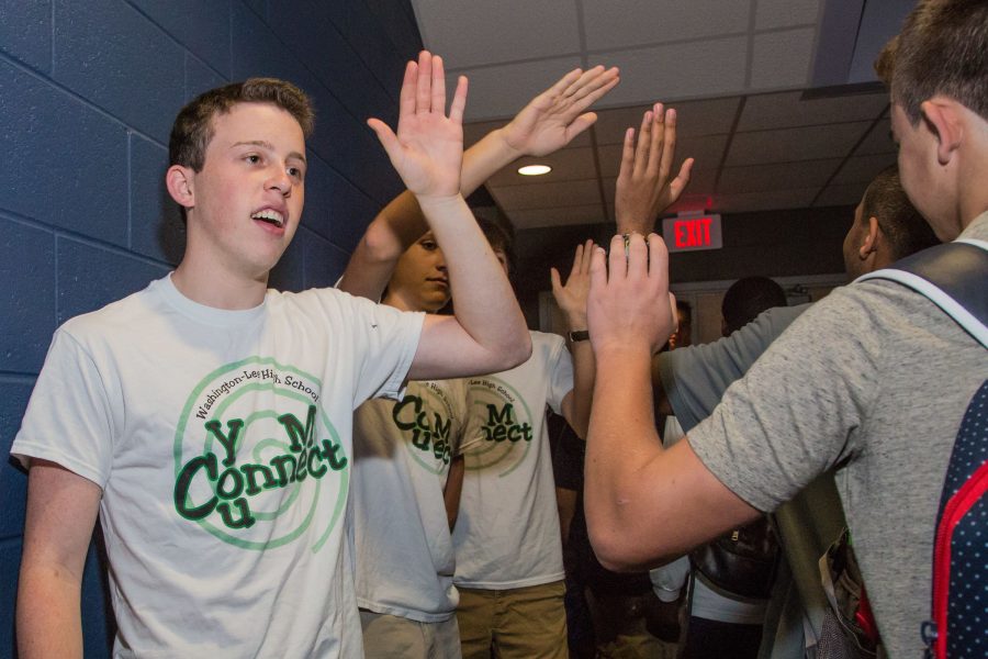 Senior Noah Kline welcomes incoming freshmen with a high five.