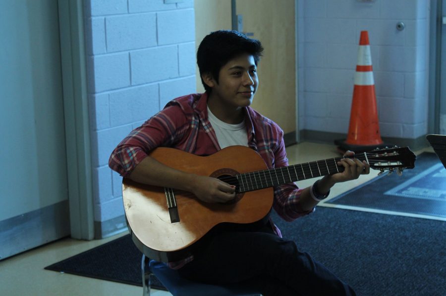 Senior Daniel L. practices guitar for his performance of Bailando by Enrique Iglesias