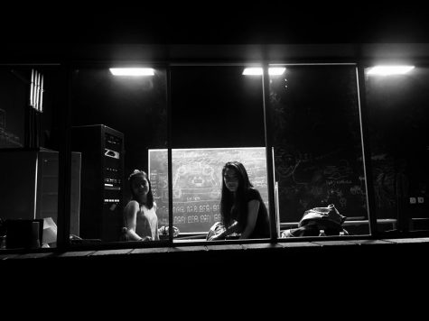 Junior co-head of lights Abby Ryan and sophomore Maya Elby look from the lights booth down to the stage below. “I design how the show looks lighting wise,” Ryan said. “We make sure that the moods look right and that people are lit.”