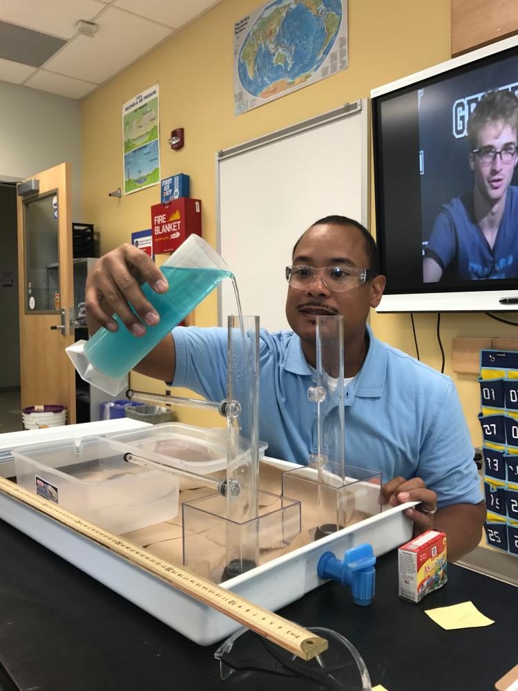 Dr.Hoo conducts an experiment in his Earth Science class.