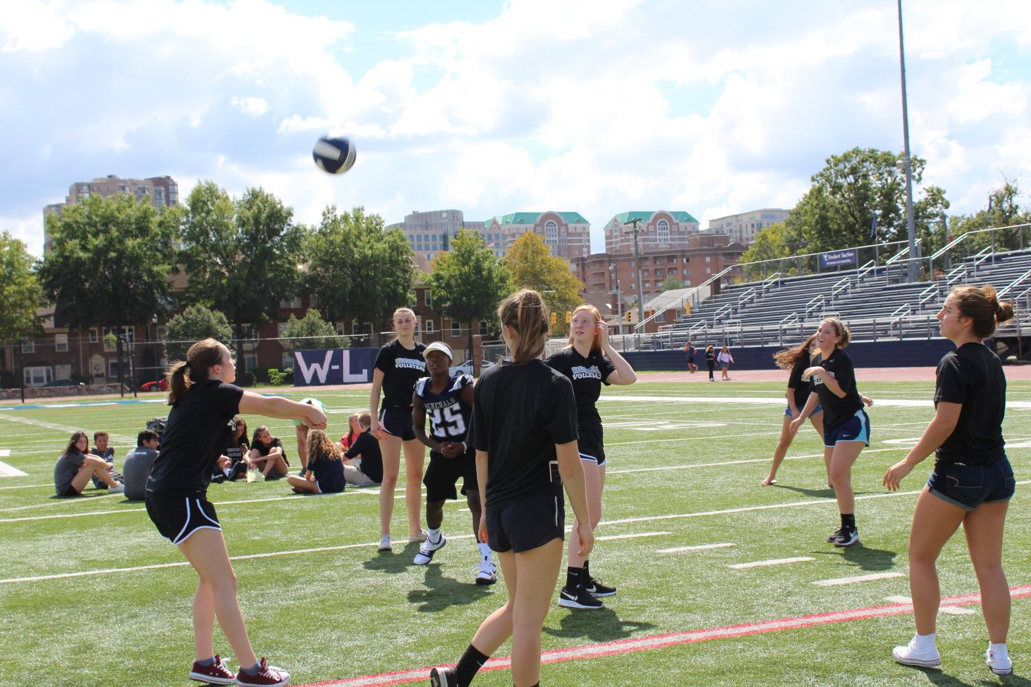 The varsity volleyball team gets the ball in the air to pump themselves for the pep rally