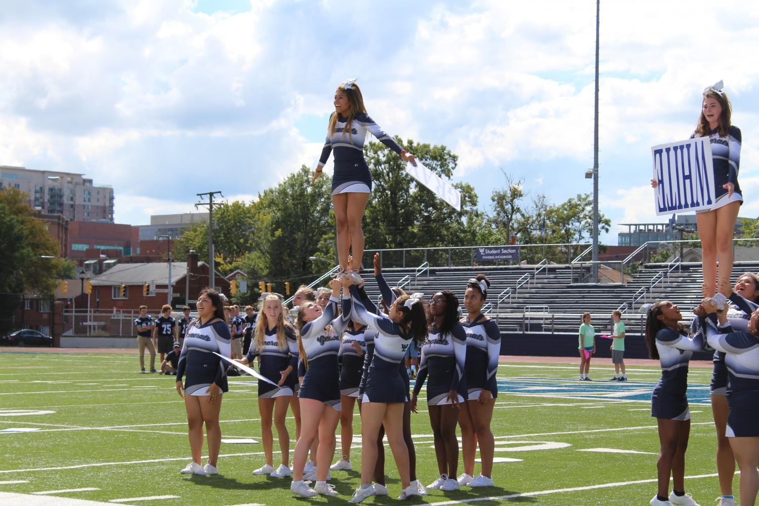 The varsity cheer team lift up one of their members during a special move in their routine