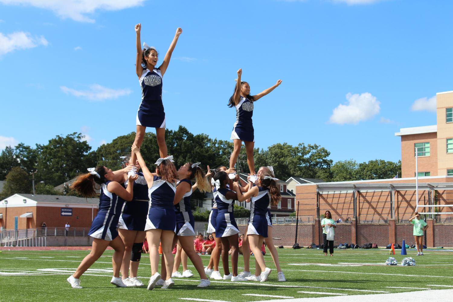 The JV cheer team lifts two of their members to pump up the crowd at the pep rally