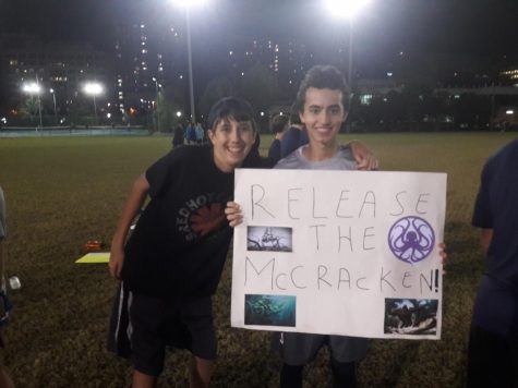 Sophomore Ethan Burka and junior Adam Edwards hold up a sign for the Frisbee team's Senior Night.