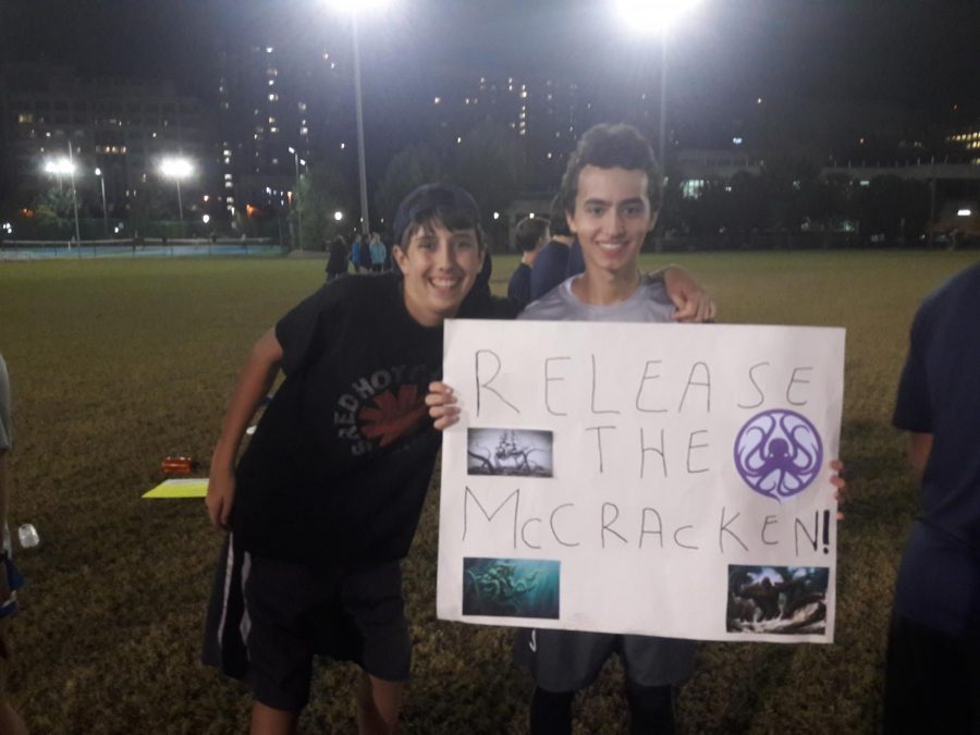 Sophomore Ethan Burka and junior Adam Edwards hold up a sign for the Frisbee teams Senior Night.