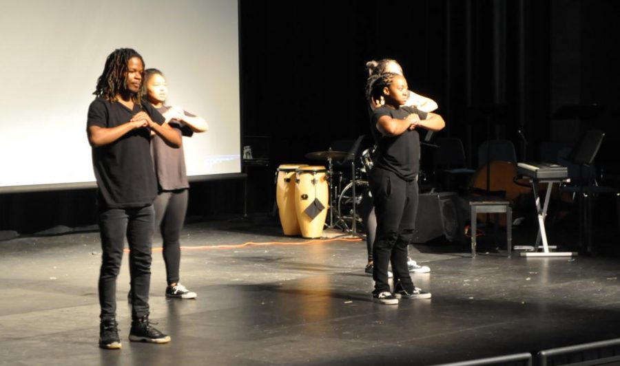 Savage performs a percussive dance on stage at the assembly. 