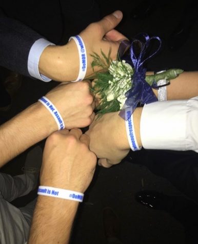 The Men of Respect club holding out their wristbands alongside homecoming goers