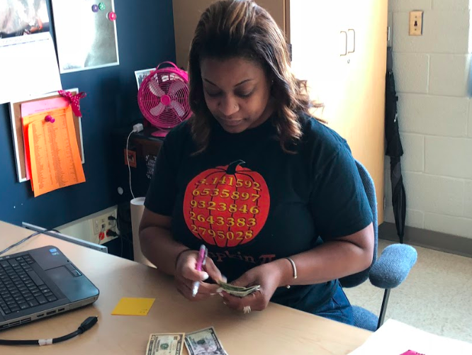 Student Council Association (SCA) advisor Ms. Timica Shivers counts money. The SCA is involved in school events throughout the year, such as the annual Homecoming dance.