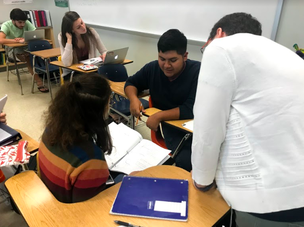 Ms. Scher helps two of her students with their calculus classwork during Generals Period.
