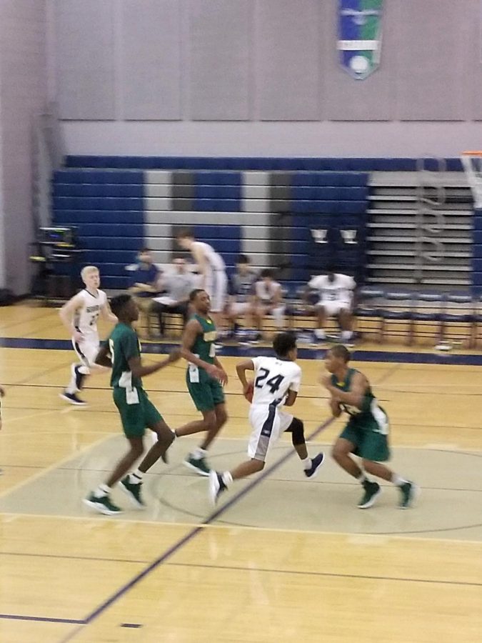 Abel Gelata, number 24, dribbles through two defenders, on his way to a reverse layup in the third quarter. Gelata was the top scorer for the Generals during this game.