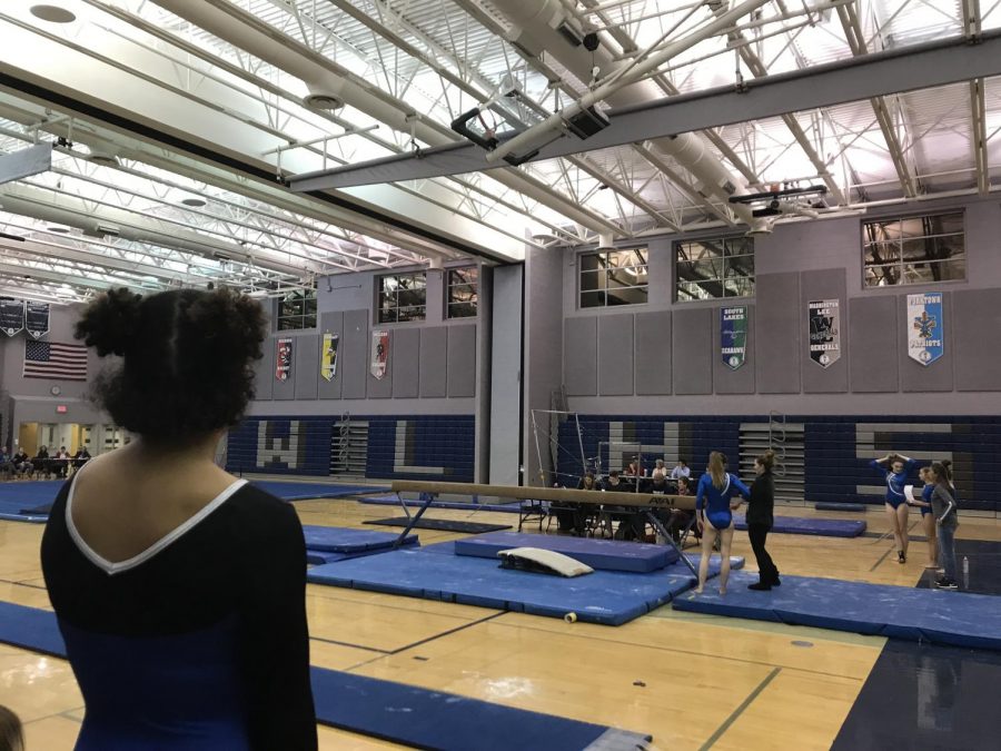Freshmen Sophia Bailey looks over the gymnastics events being held at the school, waiting for her turn on vault. This is the schools first home meet of the season against four other competing schools. 