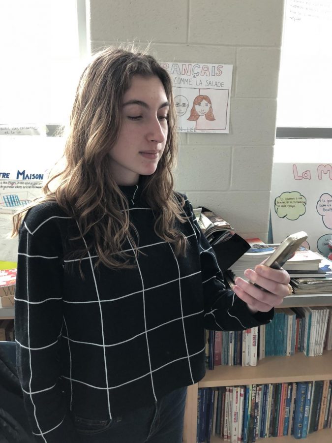 Junior Athena Butler-Christodoulou checks her phone before class. With the increase in the news that is accessible on phones and other technology, some people have become stressed about the impact that will have on them.