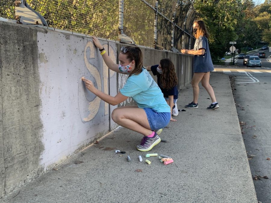 Students decorate the sidewalks near the school with chalk. The SCAs chalk decorating competition was one of their planned Homecoming Spirit Week activities.