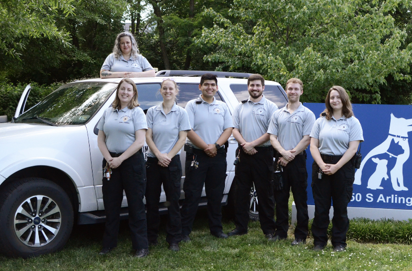 The Animal Control Officers of the Animal Welfare League of Arlington (AWLA) are pictured in front of their truck.
