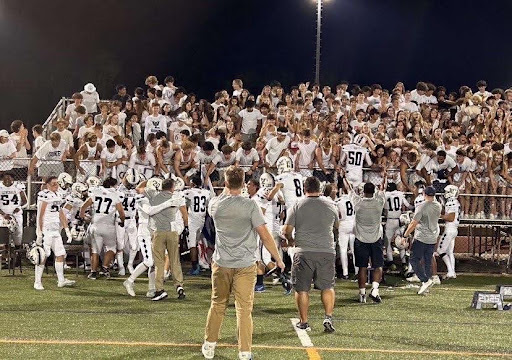 The varsity football team had an impressive record. Players celebrate with their fans and coaches following their momentous win against Yorktown High School. 
