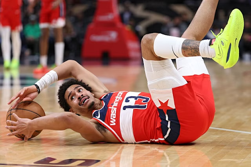 Wizards player Jordan Poole on the ground after slipping on the court.
