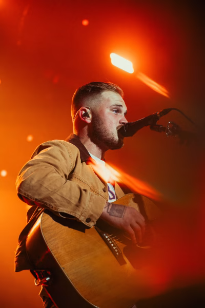 Zach Bryan performing on stage.