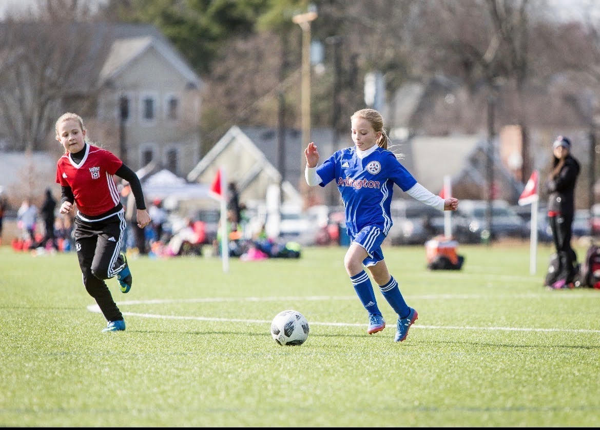 A young Bella Coffin (in blue) dribbles up the field. Coffin still plays with Arlington Soccer Academy to this day. 


