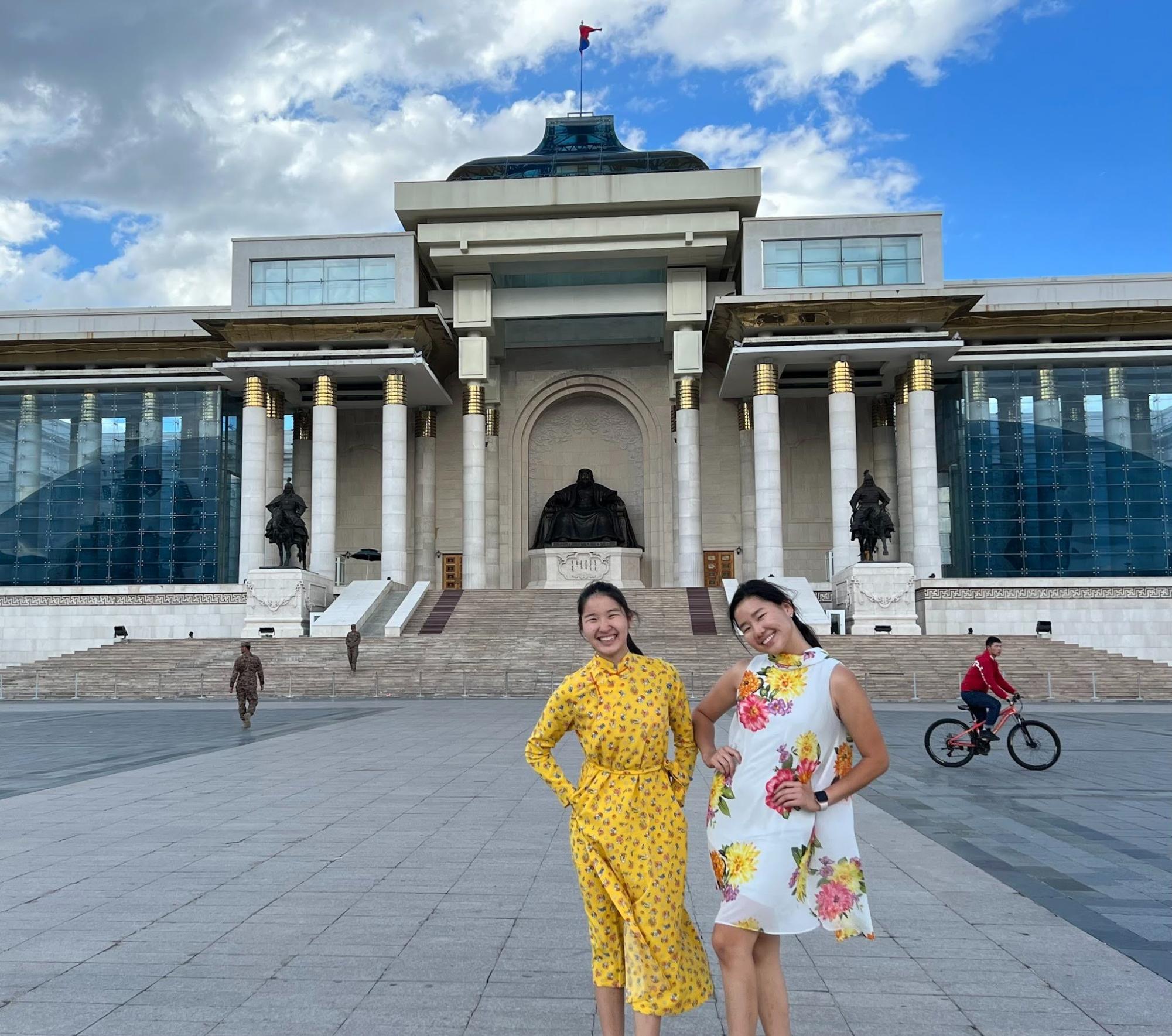 Bogol Amarbayar (left) and her sister (right) pose for a photo in front of Mongolia’s Parliament building in Sukhbaatar Square, Ulaanbaatar. 